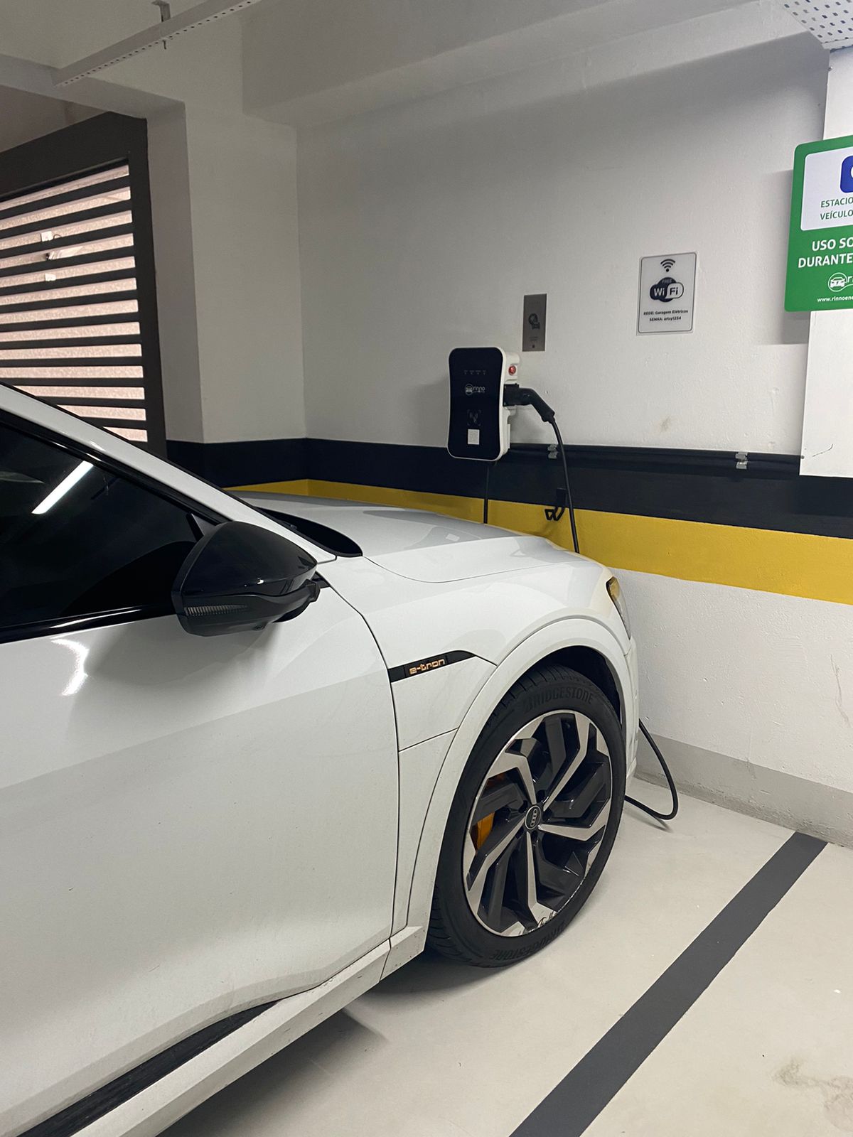 White electric car charging in a modern home garage.